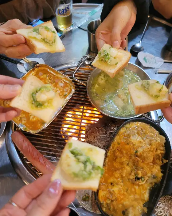 토스트 위에 조개 요리를 얹어 먹는 모습