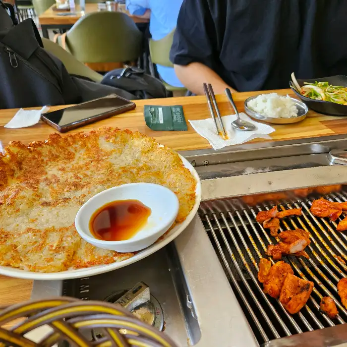 커다란 접시에 담긴 바삭한 감자전과 곁들임 소스