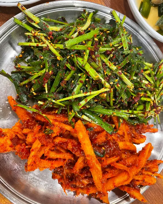 맛있게 볶아진 볶음밥 위에 신선한 채소 무침이 올라간 모습
