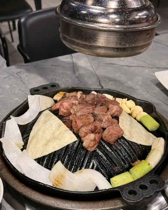 잘 익은 양갈비가 숯불구이판 중앙에 모여있다.