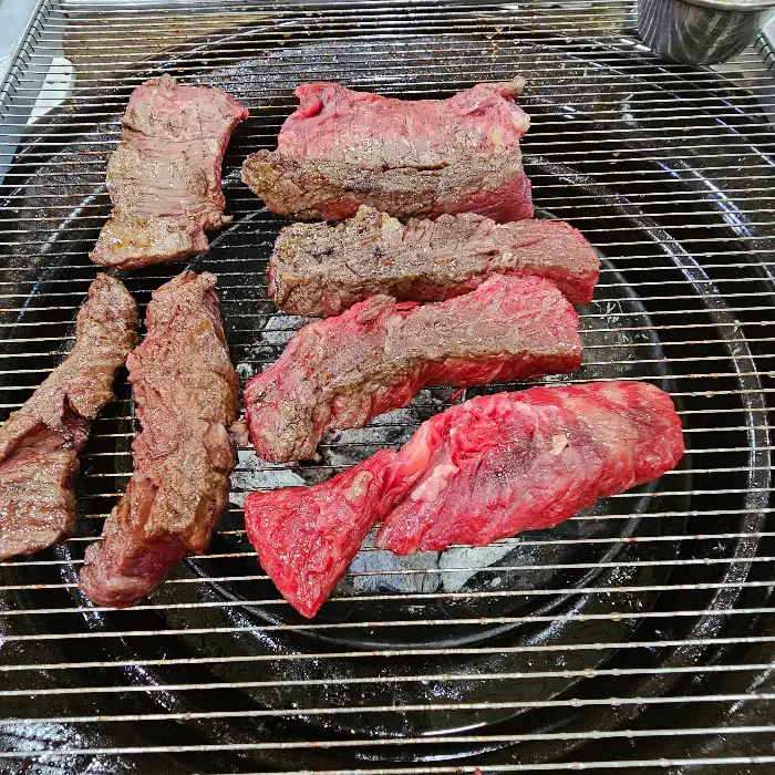 숯불 위에서 맛있게 구워지고 있는 다양한 부위의 고기