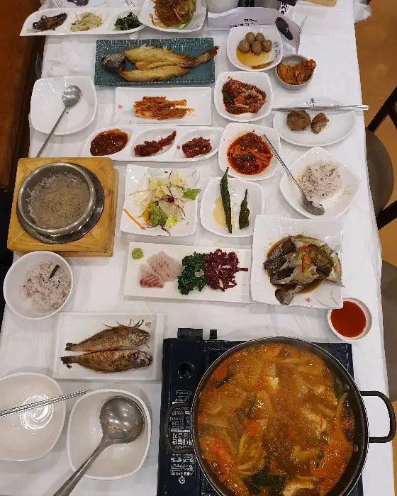 테이블에 차려진 다양한 솥밥과 국, 반찬들