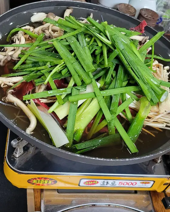 푸짐하게 담긴 육류와 채소, 버섯이 끓고 있는 냄비