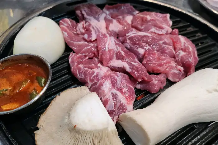 신선한 갈매기살과 버섯이 숯불 위에서 익어가는 모습