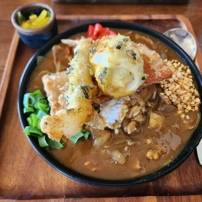 맛있게 보이는 카레라이스 위에 튀김이 올라가 있다