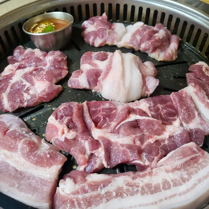 다양한 부위의 고기가 숯불 그릴 위에 올려져 익고 있는 모습