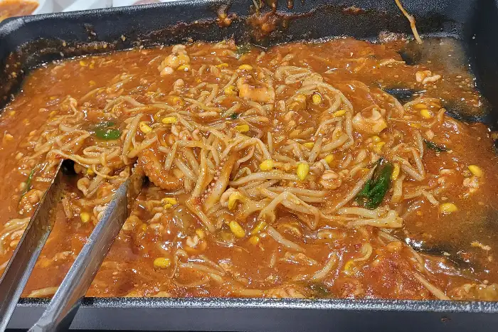 찜 요리를 집게로 집는 모습