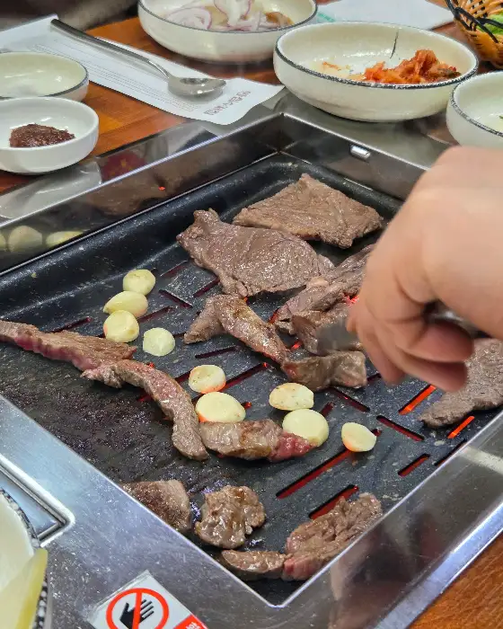 집게로 뒤집는 중인 잘 익은 소고기