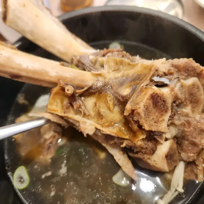 갈낙탕에 담긴 커다란 갈빗대와 함께 낙지 다리가 보이는 모습