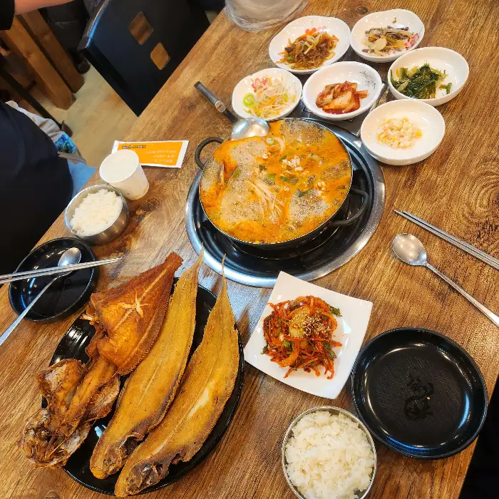 푸짐하게 차려진 꼬막무침과 여러 가지 반찬들
