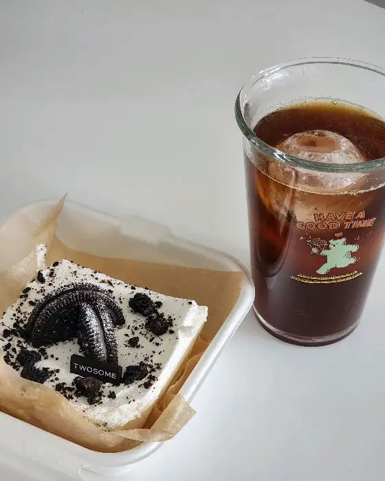 크림치즈 케이크 위에 쿠키가 올라간 디저트와 아이스 커피