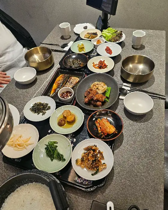 다양한 반찬들과 메인 요리가 테이블에 푸짐하게 차려져 있다.
