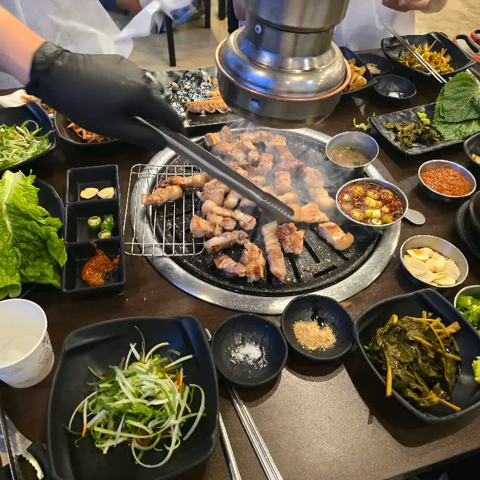 다양한 곁들임과 함께 흑돼지를 즐기는 모습