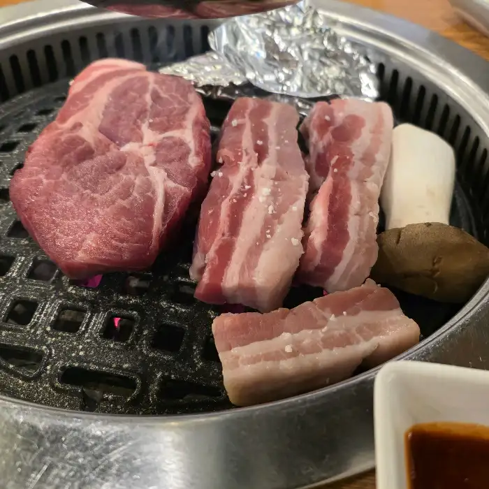 숯불 위에서 익어가는 두툼한 목살