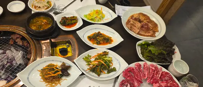 다양한 반찬과 찌개, 메인 요리가 조화롭게 차려진 식탁