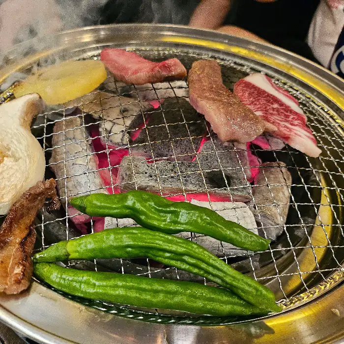 숯불 위에 올려진 다양한 종류의 고기와 야채