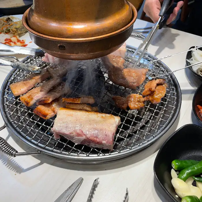 불판 위에서 구워지고 있는 다양한 고기 부위
