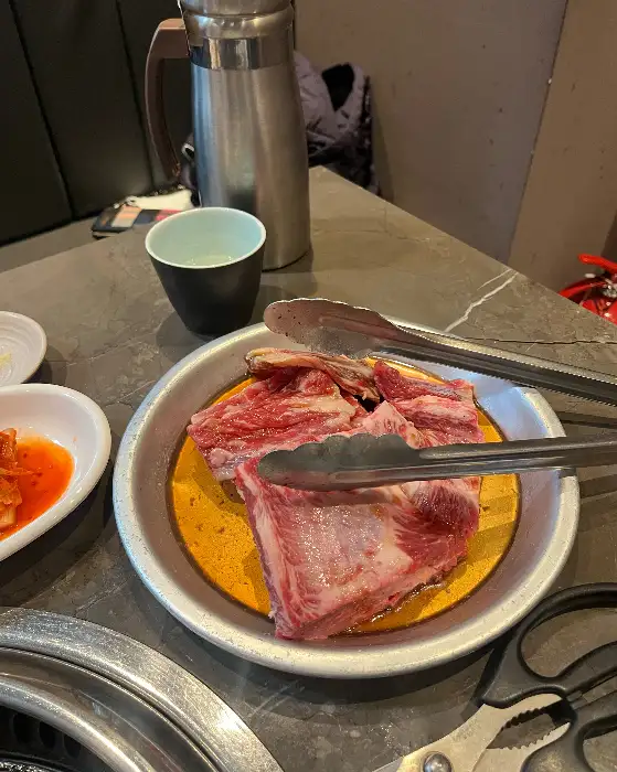 접시에 담긴 큼직한 소갈비 부위. 마블링이 선명하게 보이고 군침이 도는 비주얼이다.