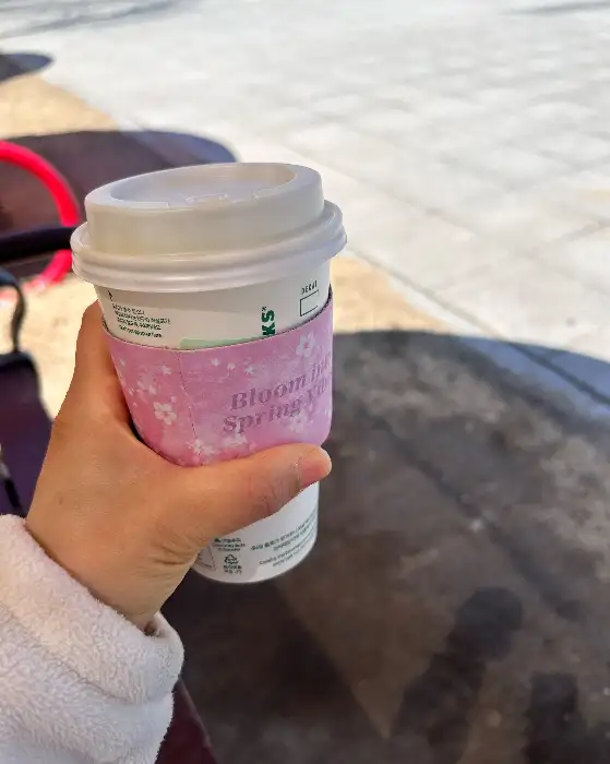 벚꽃 문양 슬리브가 낀 테이크아웃 컵