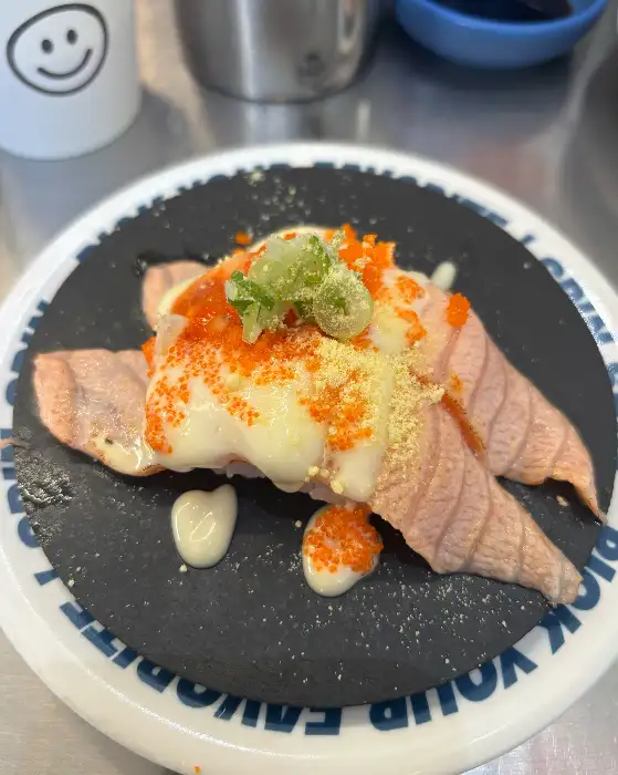 불닭연어 초밥 클로즈업, 붉은 양념과 오렌지색 연어가 먹음직스럽게 보인다.