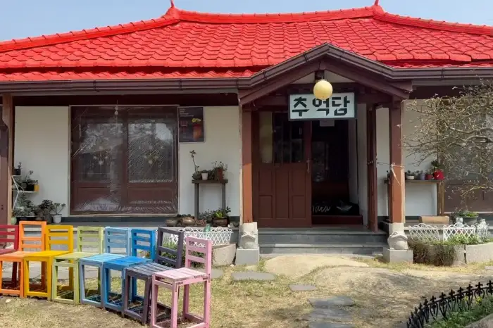 알록달록한 의자들이 카페 입구 앞에 줄지어 놓여 있어 포토존 역할을 합니다.