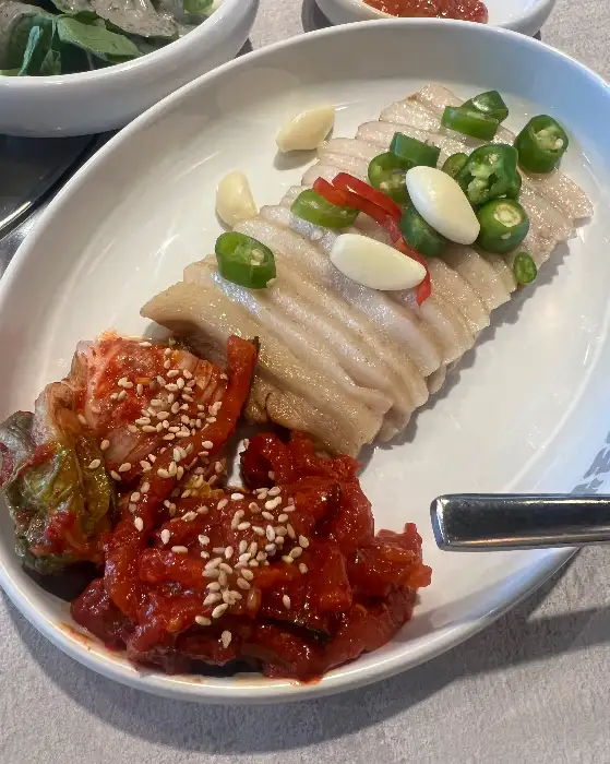 보쌈과 김치, 쌈채소를 함께 곁들여 먹는 모습