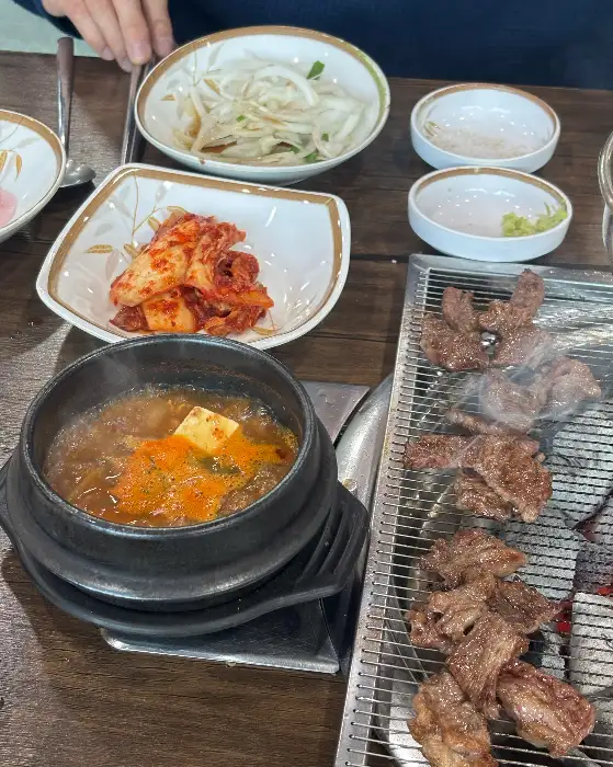 된장찌개와 곁들임 반찬, 그리고 구워지는 고기