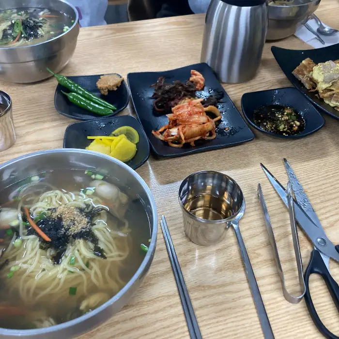 테이블 위에 놓인 국수와 육전, 그리고 밑반찬들의 모습.