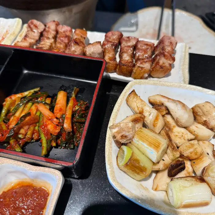 돈츄의 먹음직스러운 고기와 밑반찬 구성