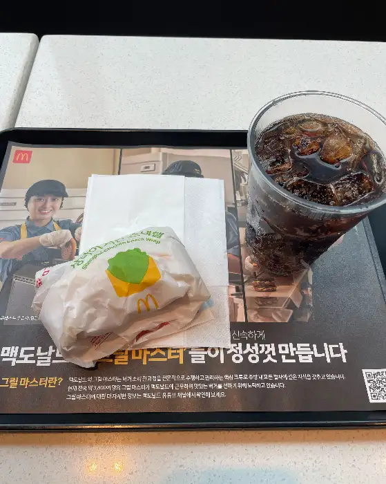 맥도날드 트레이에 콜라와 햄버거, 음료가 담겨 있는 모습