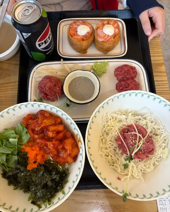 육회 비빔밥, 연어 덮밥, 육회 초밥이 담긴 테이블 세팅