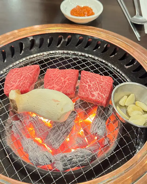 신선한 등심 부위가 숯불 위에서 구워지고 있는 모습