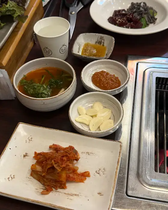 따뜻한 국물이 있는 찌개와 김치, 마늘 등 다양한 밑반찬