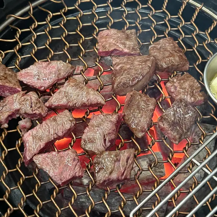 숯불 위에서 익어가는 다양한 부위의 소고기 조각들