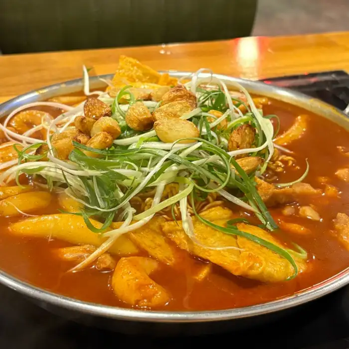 떡볶이 위에 올라간 푸짐한 토핑과 소스