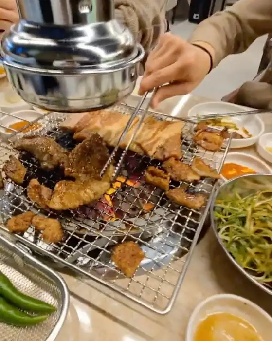 테이블에서 직접 숯불에 고기를 굽는 모습