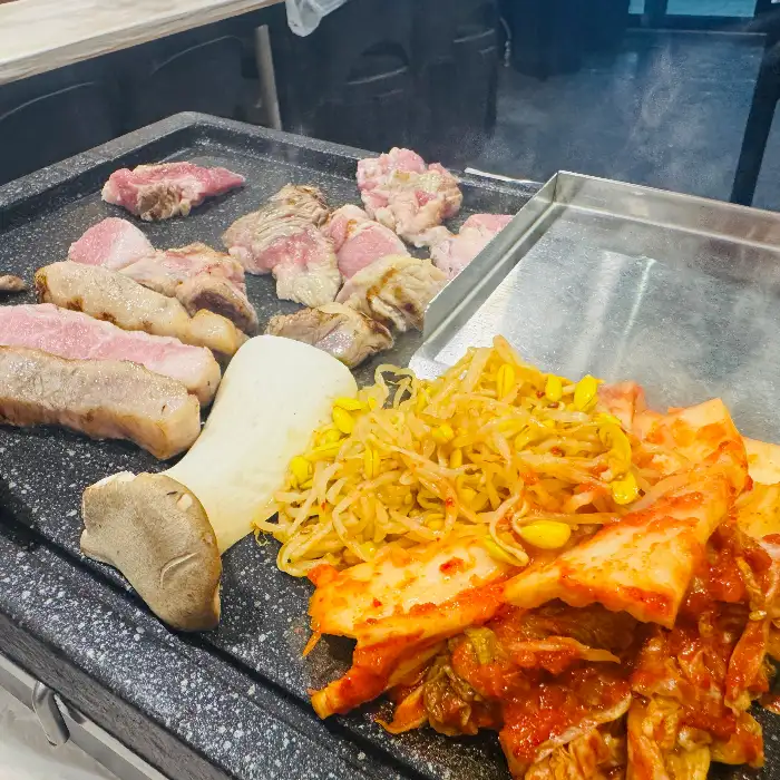 다양한 부위의 고기가 불판 위에서 익어가고 있는 모습