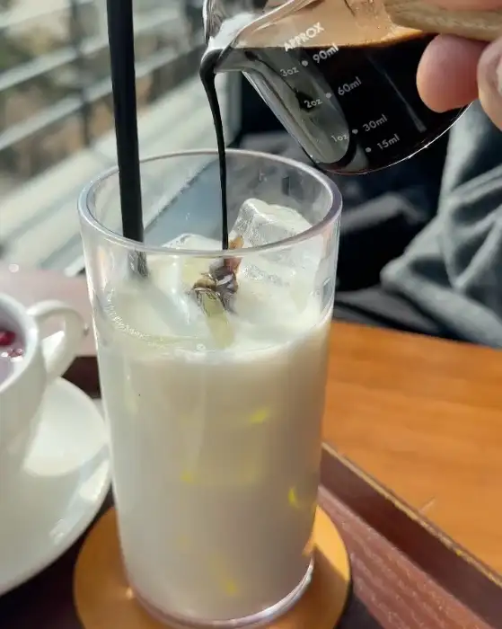 커피를 라떼 위에 붓는 모습