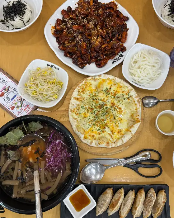 쭈꾸미볶음, 피자, 묵사발, 샐러드 등이 차려진 테이블