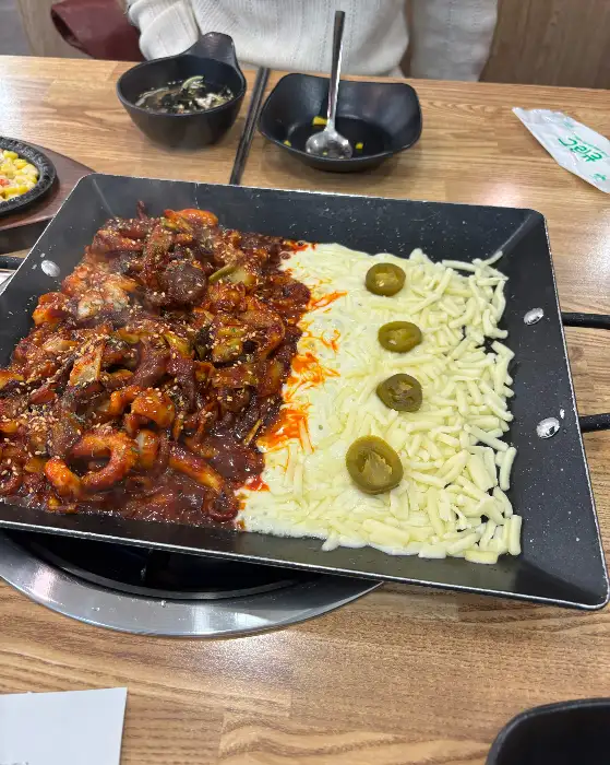 테이블 위에서 조리 중인 쭈꾸미와 치즈