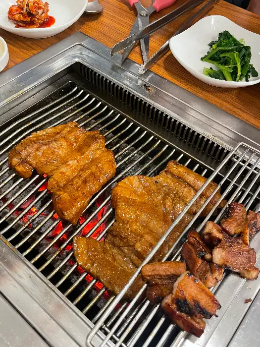 숯불 위에서 맛있게 익어가는 두툼한 돼지갈비