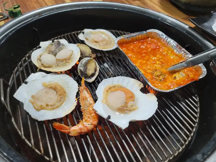 숯불 위에서 익어가고 있는 통통한 새우와 조개