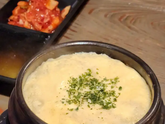 김이 모락모락 나는 매콤한 찜 요리 옆으로, 정갈하게 담겨 나온 김치. 빨간 양념이 돋보이는 김치는 새콤달콤한 맛으로 입맛을 돋우는 역할을 한다.
