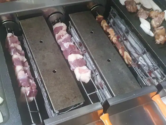 회전구이 불판에 올려질 오리고기 꼬치들