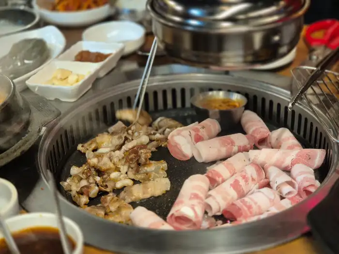 불판 위에 올라간 삼겹살과 대패 삼겹살