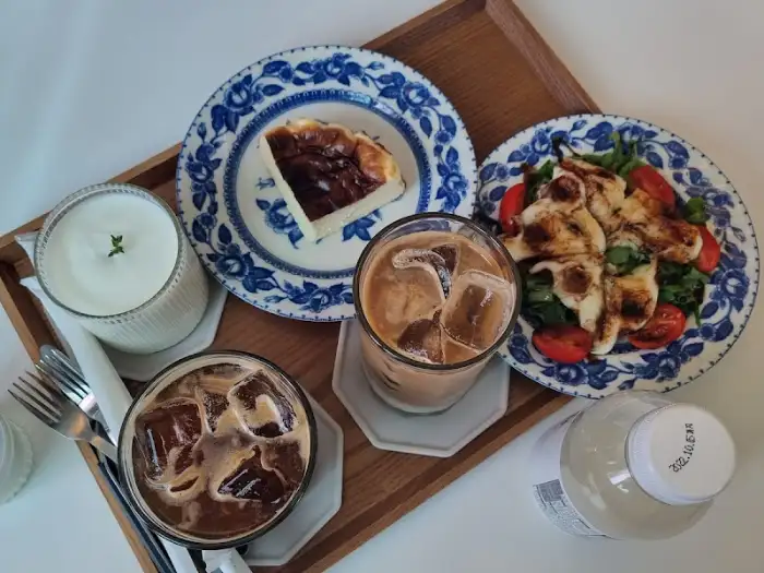 우유, 아이스 라떼, 산양유 요거트, 치즈 와플, 치즈 케이크가 담긴 트레이