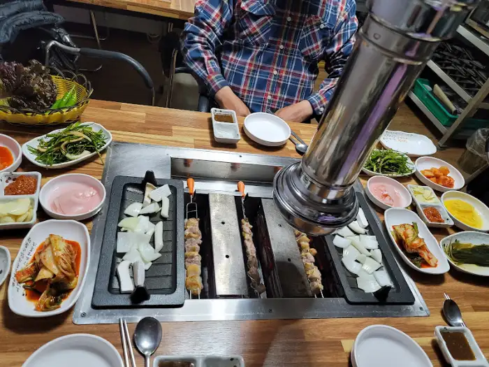 테이블에 세팅된 오리고기 회전구이 불판과 반찬들