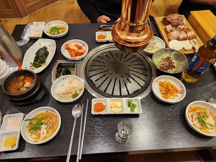 테이블 위 가득한 음식과 숯불구이 기구
