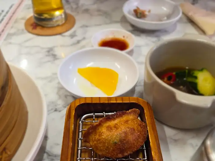따뜻한 찜기에서 나온 고기만두와 곁들임 반찬들