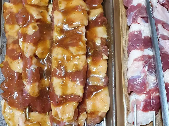 붉은 양념이 먹음직스러운 오리고기 꼬치 클로즈업